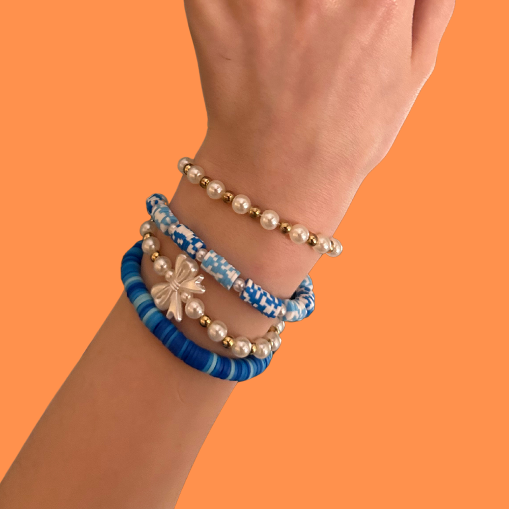 Cobalt and gold bracelets on a bright orange background