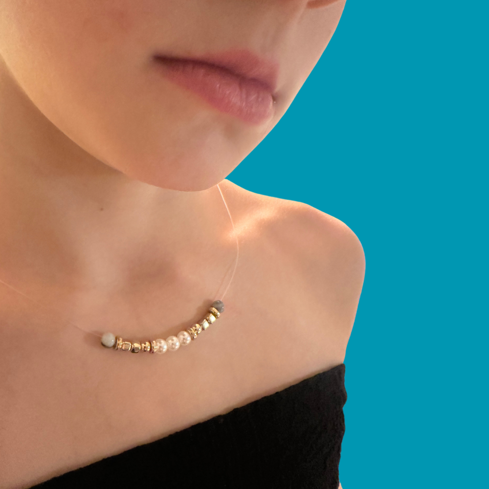 Pearl and gold bead necklace worn on a teal background