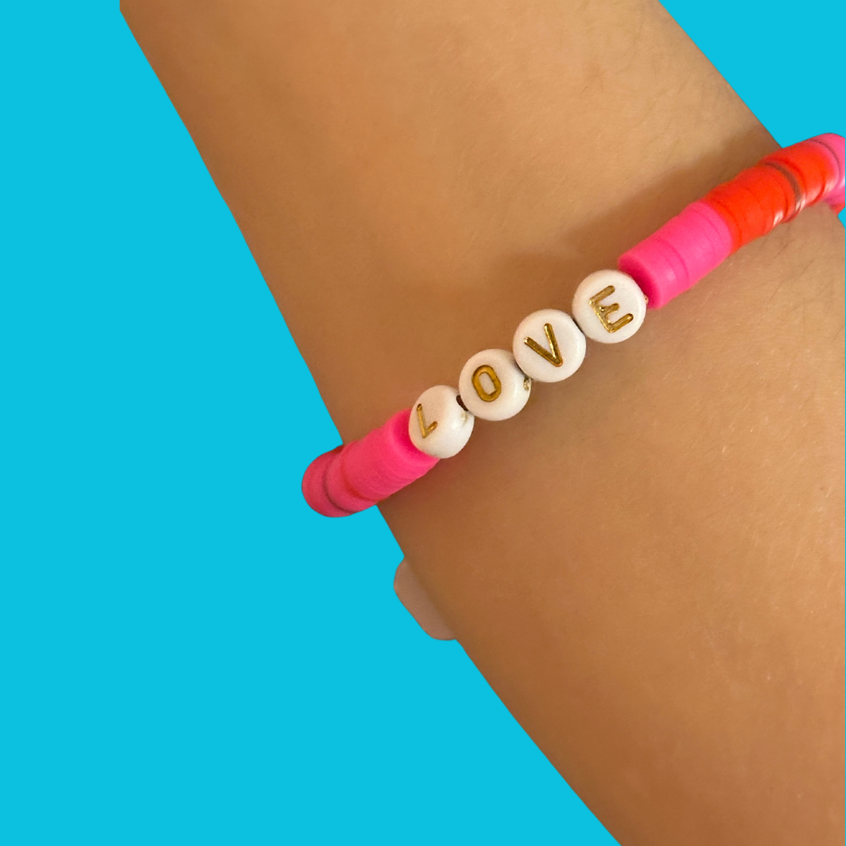 Neon pink LOVE letter bracelet on a teal background